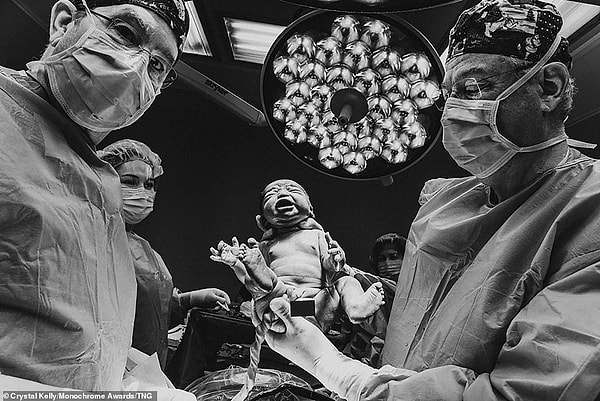 Кристал Келли родила дочь с помощью кесарева сечения 10 декабря 2019 года в США. Она сделала эту фотографию, которая заняла третье место в категории «Фотожурналистика», и сказала: «Я сделала эту фотографию, когда она сделала свой первый вдох, будучи все еще привязанный ко мне».