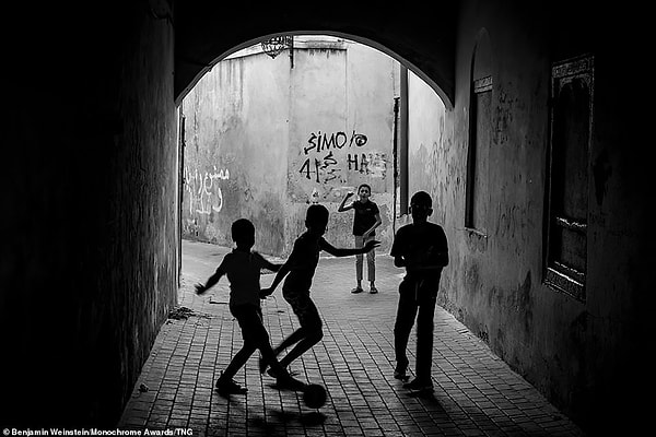 Дети играют в футбол в переулке Феса в Марокко. Американский фотограф Бенджамин Вайнштейн занял второе место в категории профессиональных уличных фотографов за свою фотографию.