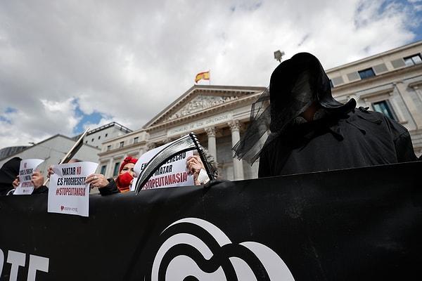 Meclis binasının karşısında toplanan ötanazi karşıtı gruplar, "Ölüm hükümeti" yazılı pankart açtı.