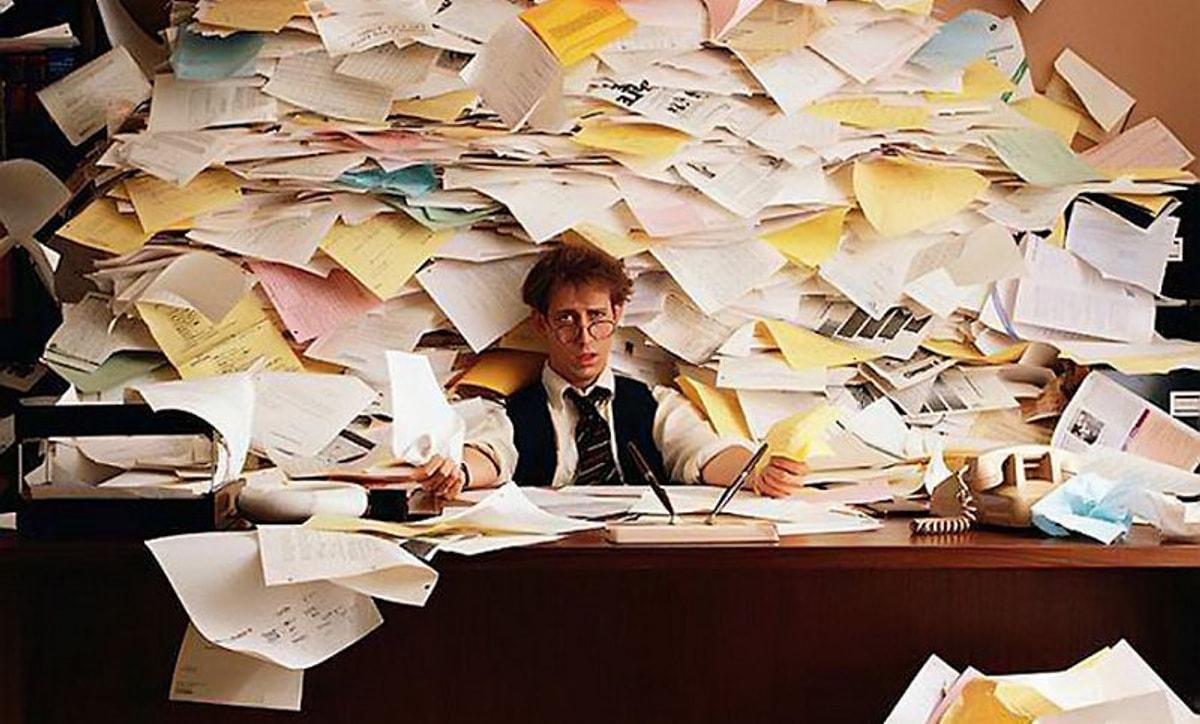Тотальные работы. Человек с бумагами. Человек и много бумаг. Куча бумаг в офисе. Стол заваленный бумагами.