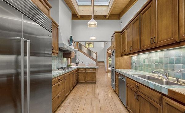 Üst düzey paslanmaz cihazlarla donanmış olsa da, mutfağın geri kalanı için bir tasarım yenilemesi yapılabilir gibi görünüyor. İyi yönden bakacak olursak, bol miktarda doğal ışık için büyük bir tavan penceresi bulunuyor.