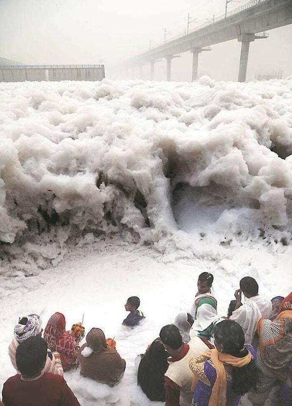 10. Hindistan'da endüstriyel atıklardan köpüren Yamuna Nehri'nde dua eden insanlar.