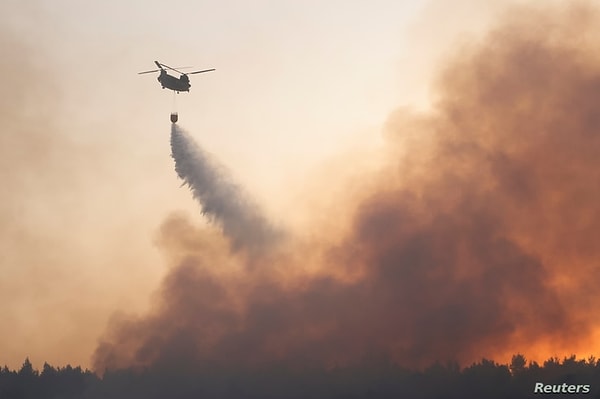 5. Atina'nın kuzeyinde yer alan Varympompi mahallesindeki yangını söndürmeye çalışan bir helikopter.
