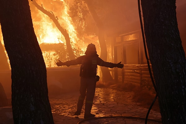 10. Yunanistan'ın çeşitli bölgelerindeki yangınlarla mücadele etmeye çalışan itfaiyecilerden sadece bir tanesi.