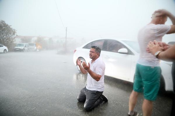 Kalemler Mahallesi'nde bir vatandaş, asfaltta dizlerinin üzerine çöküp yağmur altında dua etti.