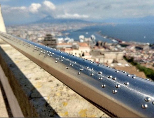 16. Bu metal korkulukta Braille alfabesiyle manzara tasvir edilmiş: