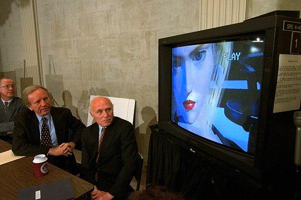 13. Senatör Joe Lieberman ve Senatör Herb Kohl video oyunlarının derecelendirilmesi ile ilgili bir oturumun ardından basın toplantısında bir oyunun videosunu izliyorlar. -1996