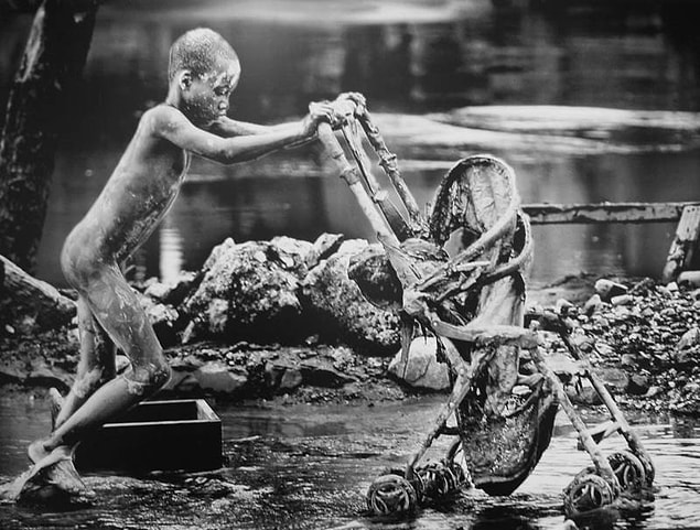 16. Tropik bir fırtına 2008'de Haiti'yi vurduktan sonra genç bir çocuk bir bebek arabasını kurtarıyor.