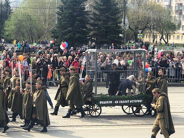 28. İkinci Dünya Savaşı anmalarında bir Naziyi ayrıca kafes içerisine köpek koyarak sembolleyen Rus askerler.