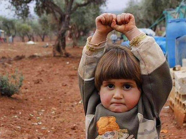 12. "Bu fotoğraf birçoğumuza tanıdık geliyordur. Oldukça şirin ve masum görünen bu Suriyeli çocuğun ellerini havaya kaldırmasının sebebi ise kamerayı silah zannetmesi..."
