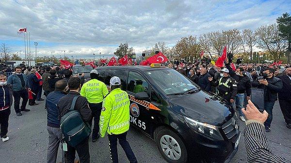 Üzerinde "Emeğe saygı, itibar suikastına son", "Esnaf sizin siyasi oyuncağınız değil" yazılı pankartlar asılan alanda toplanan taksiciler, UKOME toplantısı devam ederken dışarıda ellerinde Türk bayrakları ile eylem yapıyor.