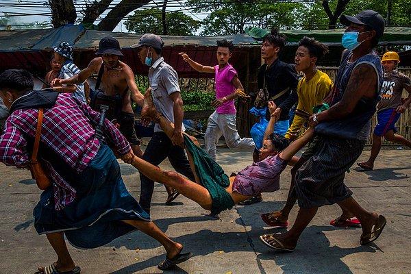 26. İnsanlar, 14 Mart'ta Myanmar'ın Yangon kentinde darbe karşıtı protestoculara yönelik baskı sırasında vurulan bir adamı taşıyor.