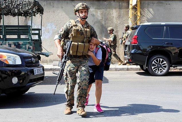 34. Mohamed Azakir imzalı fotoğrafta Lübnan'ın Beyrut şehrinde yaşanan çatışma sırasında bir öğrenciyi koruyan bir ordu askeri görüntülendi.