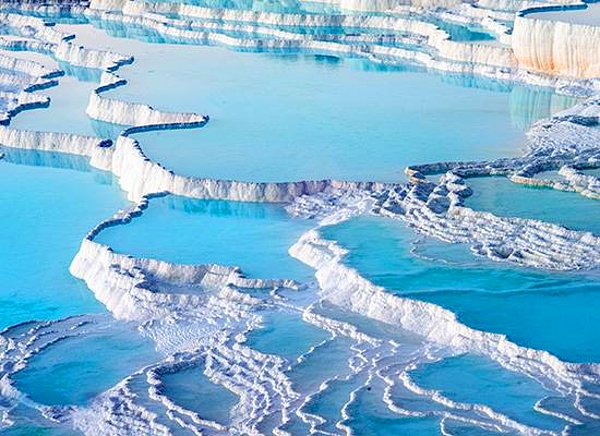 Pamukkale'deki travertenler, Türkiye'nin en gözde turizm noktaları arasında yer alıyor. Bu benzersiz yapı, 400 bin yıl boyunca zengin minerallere sahip doğal kaynak suyunun köpürmesi sonucu geride bıraktığı kireçtaşı kayalıkların yavaş yavaş birikmesiyle oluştu.