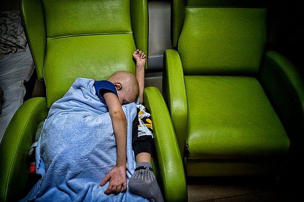Koltukta uyuyan lösemi hastası bir çocuk.