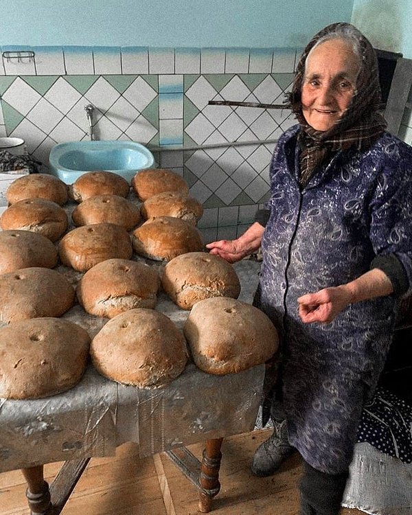 13. "Ternopil bölgesinden yaşlı bir kadın, ülkeyi savunan Ukraynalı askerler için ekmek pişiriyor."