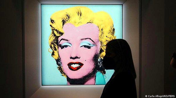 Marilyn Monroe'nun 1953 yapımı Niagara filminin basın gösterimindeki görüntüsünün bir temsili olan Blue Marilyn, Warhol'un 1964'te şehir merkezindeki stüdyosunda, isimsiz bir ziyaretçinin bir yığın tabloya ateş edip hasar verdiği bir olaydan sonra ürettiği “Shot Marilyn” portre serisinden geliyor.