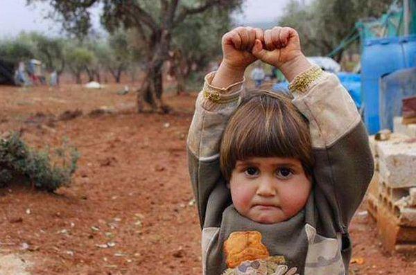 6. Suriye'de kendisinin fotoğrafını çeken fotoğrafçının makinasını silah zannettiği için ellerini havaya kaldıran 4 yaşındaki Adi Hudea: