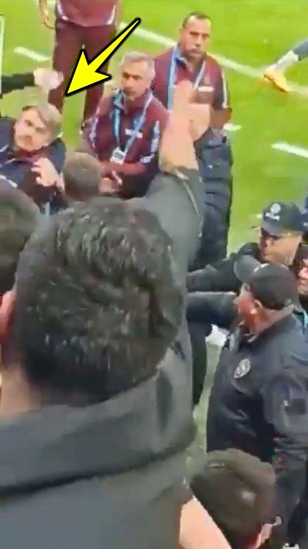 Trabzonspor yardımcı antrenörü Orhan Ak elindeki bir cismi taraftarlara atıyor.