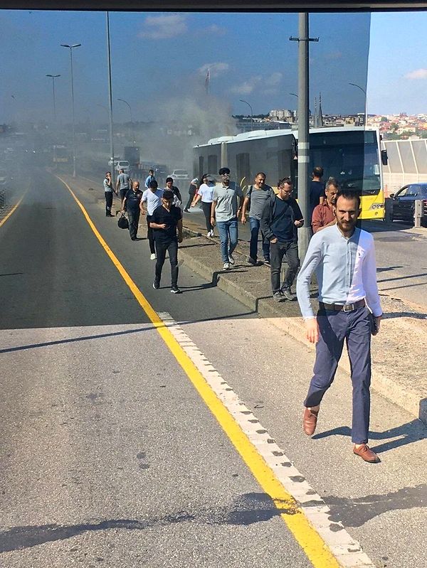 Yanan metrobüste bulunan yolcular yürüyerek köprü üzerinden bir sonraki durağa gitmeye çalışıyor.