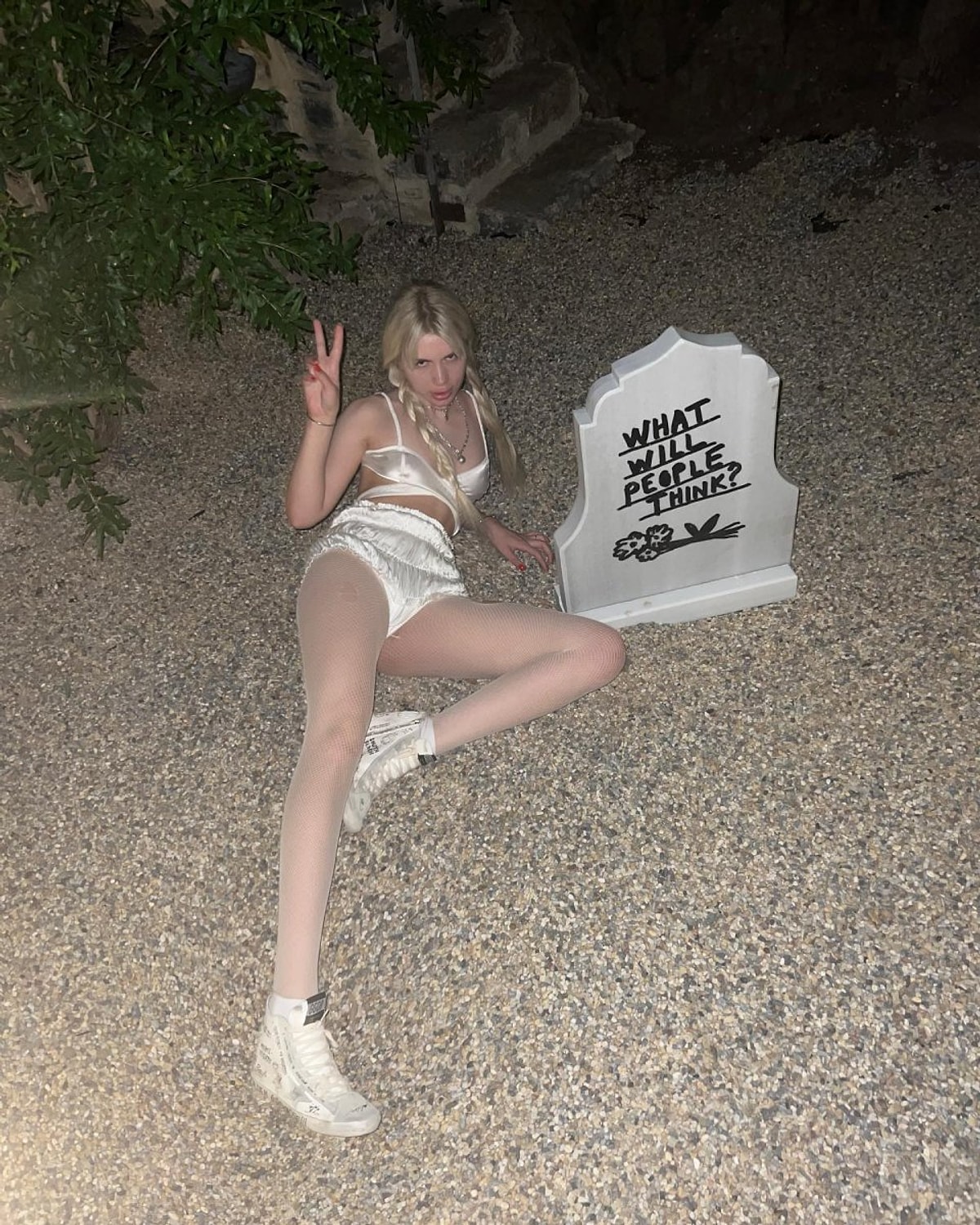 En son "İnsanlar ne düşünecek?" yazılı bir mezar taşının önünde p...