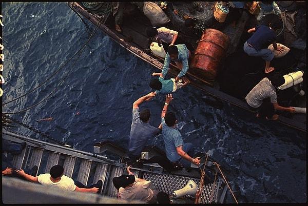 8. USS Durham kargo gemisinin mürettebatı Vietnamlı mültecileri küçük bir gemiden alırken: (1975)