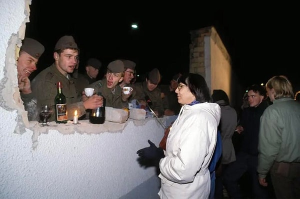 12. Batıdaki Almanların Berlin Duvarı'nın yıkılmasından sonra Doğu Alman sınır askerlerine yiyecek ve içecek getirdiği esnada çekilen fotoğraf - 10 Kasım 1989:
