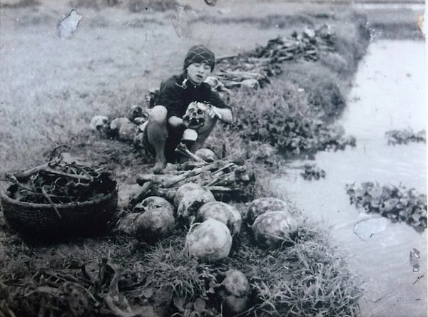 15. Vietnam'da 2 milyon insanın hayatını kaybetmesine sebep olan 1945 büyük kıtlığın ardından yapılacak cenaze öncesi hayatını kaybeden kişilerin kemiklerini yıkayan kadın: