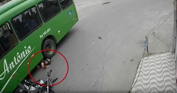 Motosikletten düştükten sonra otobüsün altında kalan adam tekerlek tarafından ezilmekten ise son saniyede kurtuluyor.