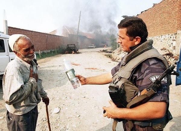 14. Sırp Polis memurunun yaşlı bir Arnavuta su ikram ettiği an - Kosova, 1998: