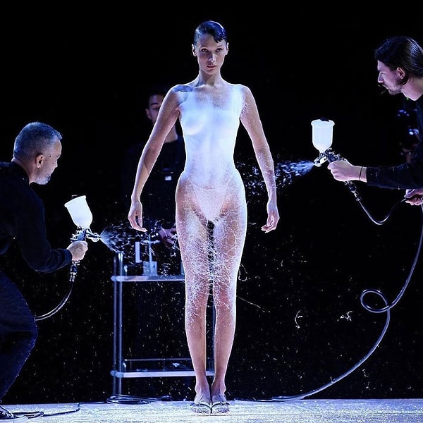 Примерно через 9 минут тело Беллы было окутано тонким слоем белой ткани. Шарлотта Рэймонд, руководитель отдела дизайна Coperni, придала платью окончательный вид.