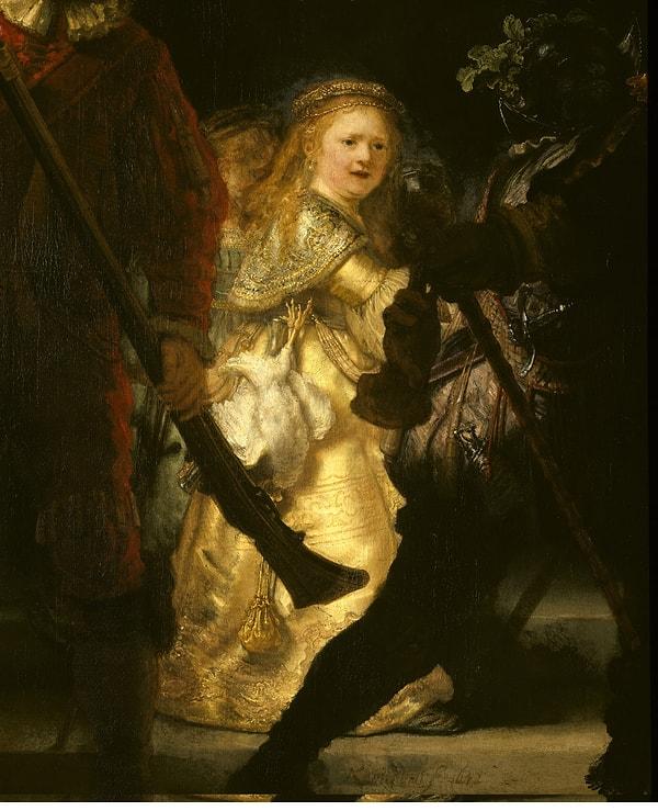Bu sarışın kız çocuğu figürü askeriyenin bir parçası değil, kendisi bir maskot. Tabloyu görenler bu kızın Rembrandt’ın rahmetli eşi Saskia veya bir melek olduğuna dair pek çok fikir ortaya sunuyorlar.