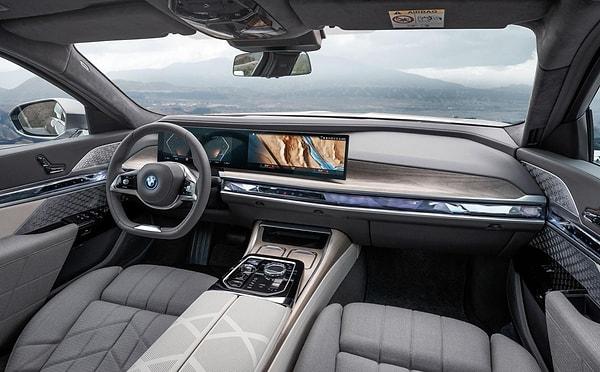 BMW i7'nin iç mekânında iki kollu direksiyon simidi ve bitişik ekranlardan oluşan kavisli panel bizleri karşılıyor.