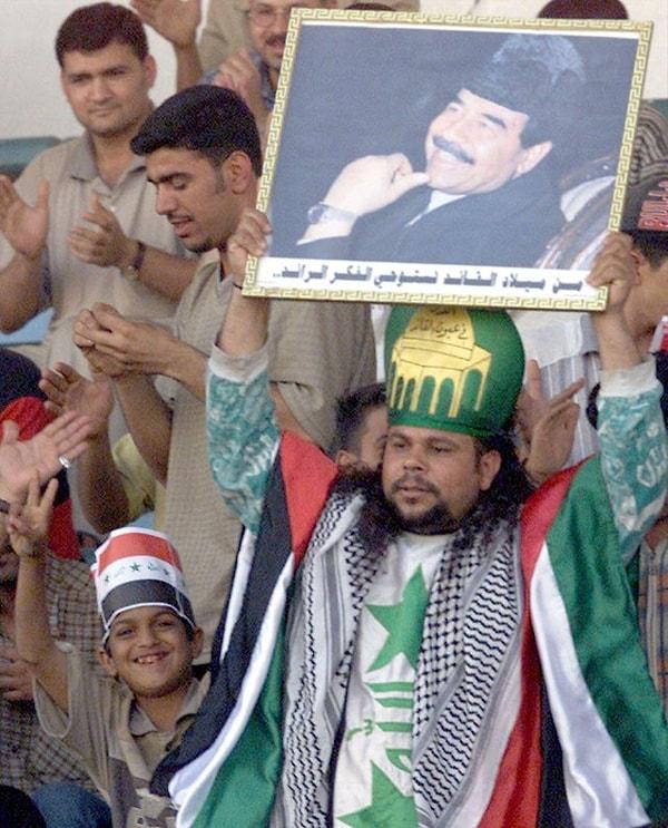 7. Iraklı bir taraftar, 14 Nisan 2001 yılında Bağdat'ta Irak'ın Nepal'e karşı oynadığı Dünya Kupası ön eleme maçında Saddam Hüseyin'in fotoğrafını tutarken: