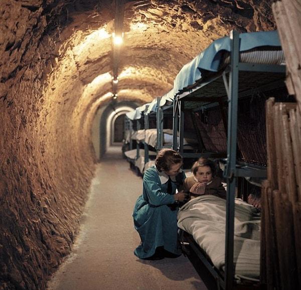 15. İkinci Dünya Savaşı sırasında Londra bombalanırken tünellerdeki sığınaklarda çocuğunu sakinleştiren anne.