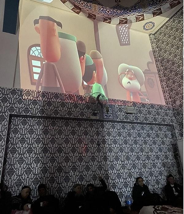 Camiye sığınan insanların çocukları için duvara çizgi film yansıtan imam ise takdir topladı.