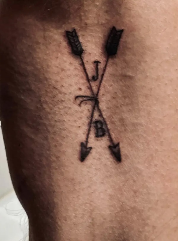 Бен, похоже, выбрал немного другой дизайн — две скрещенные стрелки с буквами «J» и «B», расположенные сверху и снизу. Кажется, татуировка набита на руке