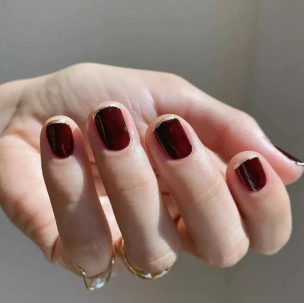 9. Let your nails shine like stars with burgundy and gold glitter with pinstripe French manicure!