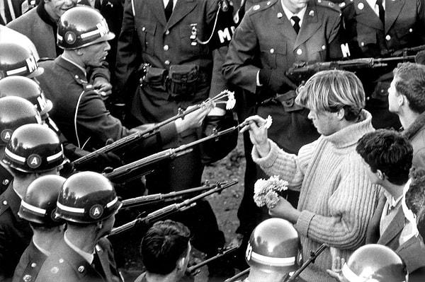 9. Savaş karşıtı göstericiler, Pentagon binasının önündeki askerlerin silahlarına çiçekler koyuyor. (21 Ekim, 1967)