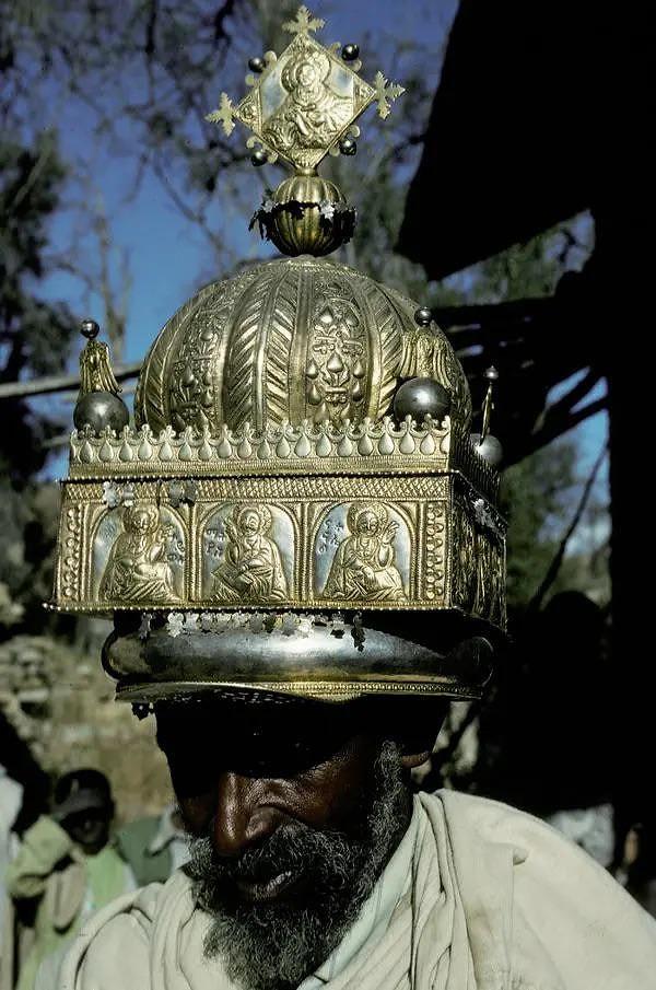 12. Etiyopyalı bir rahip, çalınmadan önce var olan yaklaşık 20 liturjik taçtan birini takarken, 1993
