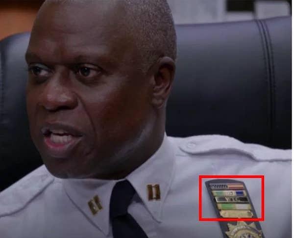 8. Brooklyn Nine Nine dizisindeki Kaptan Holt, WTC'yi temsil eden armalardan takıyor.