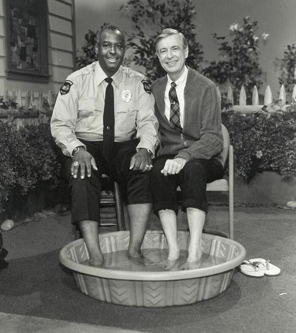 4. Siyahi bireylerin halen beyazlarla yüzmesine izin verilmediği 1969 yılında, Mr. Rogers, polis memuru Clemmons ile ayaklarını havuzda serinletiyor.
