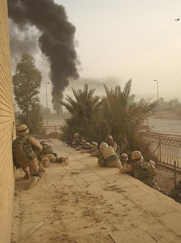 2. ABD ordusunun B Bölüğü, 2. Tabur, 325. Hava İndirme Piyade Alayından askerler, Irak'a Özgürlük Operasyonu sırasında Samava şehrinin kuzey tarafına yapılan bir saldırı sırasında Iraklı bir paramiliter birliğin karargâhının yanışını izliyor. (2003)