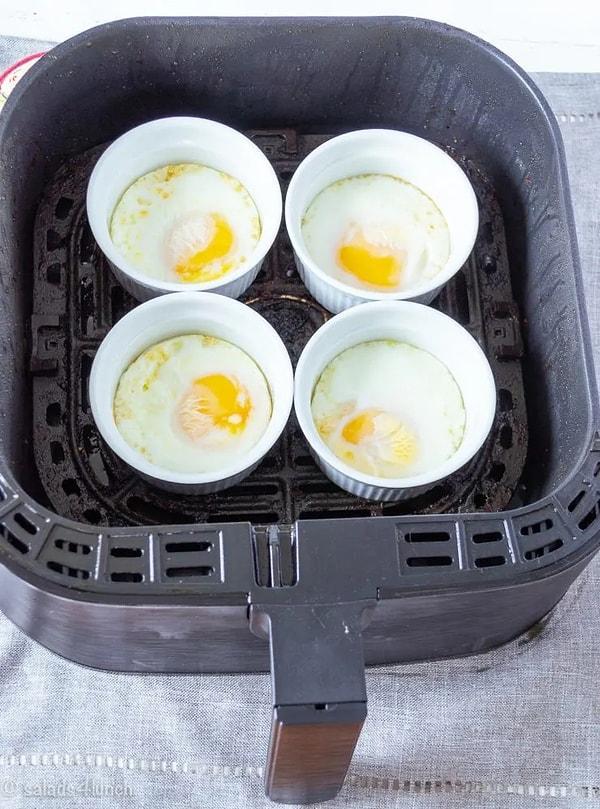 Her bir sufle kabının içine bir yumurta kırın ve her birine yaklaşık 2 yemek kaşığı su ekleyin.