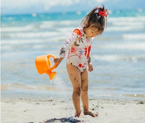 7. Çocuğunuz için UV korumalı bir mayo ve kumda ekstra eğlence için bir kova seti.