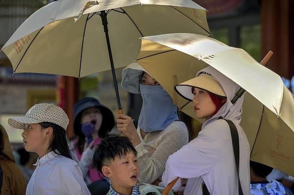 Çin devlet televizyonlarında yayınlanan görüntülerde, geçtiğimiz hafta geniş kenarlı şapkalar takan ve ekstra koruma için şemsiye kullanan kalabalıklar bölgeye akın etmiş durumda.