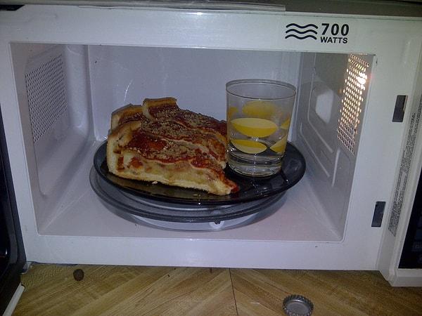 12. Mikrodalga fırında pizzanızı ısıtırken üstünün kurumaması için bir bardağa su koyun.