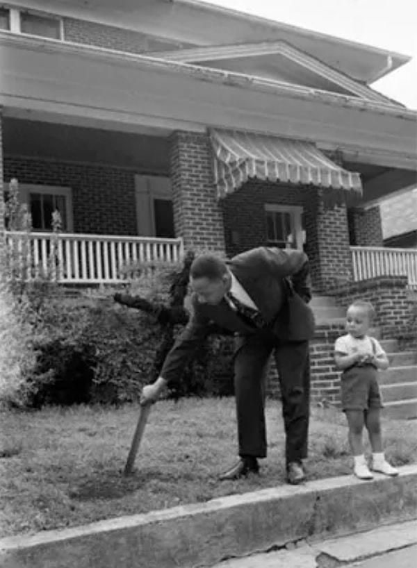7. Martin Luther King bahçesinin çimlerinden bir haç çıkarıyor.
