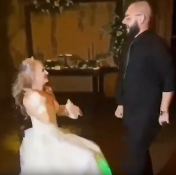 Geline karşı dansını yapan damat ardından ise zor bir hareket deneyerek ayağını gelinin kafasının üzerinden geçirmeye çalışıyor.