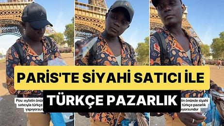 Paris'te Eyfel Kulesinin Önünde Siyahi Satıcı ile Türkçe Pazarlık Yapan Gençler
